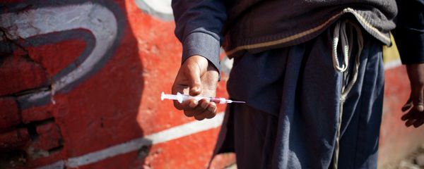 A drug addict holds a needle and syringe. - Sputnik International