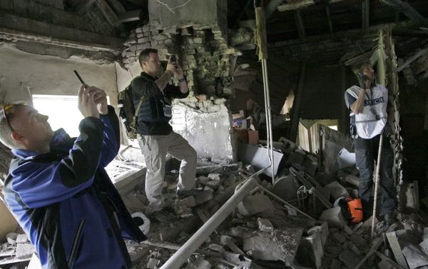 Members of the Organization for Security and Co-operation in Europe (OSCE) work within the ruins of a residential building, which according to locals was recently damaged by shelling, in Donetsk, Ukraine Members of the Organization for Security and Co-operation in Europe (OSCE) work within the ruins of a residential building, which according to locals was recently damaged by shelling, in Donetsk, Ukraine - Sputnik International