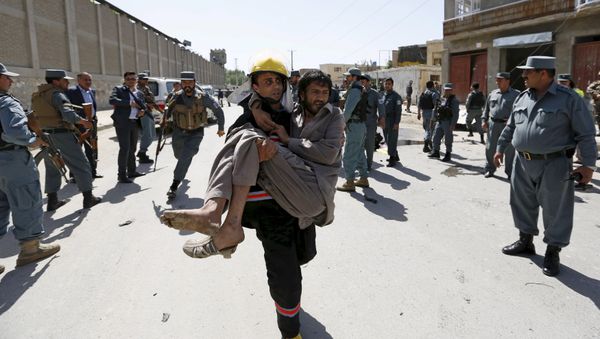 An Afghan policeman carries an injured man after an attack in Kabul, Afghanistan in this May 17, 2015 file photo An Afghan policeman carries an injured man after an attack in Kabul, Afghanistan in this May 17, 2015 file photo - Sputnik International