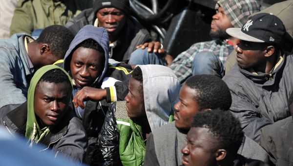 People wait after disembarking from tanker Maria Bottiglieriin carrying more than 110 Central African migrants, men and women, on April 15, 2015 in the port of Corigliano Calabro - Sputnik International