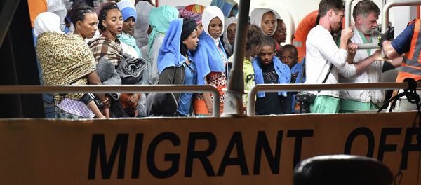 Migrants wait to disembark from the Migrant Offshore Aid Station (MOAS) ship Phoenix in the Sicilian port town of Augusta, Italy, Sunday, June 7, 2015 - Sputnik International