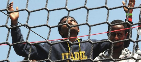 A migrant opens his arms as he waits to disembark from the German Navy ship Hessen at the Palermo harbor, Italy. A migrant opens his arms as he waits to disembark from the German Navy ship Hessen at the Palermo harbor, Italy. - Sputnik International