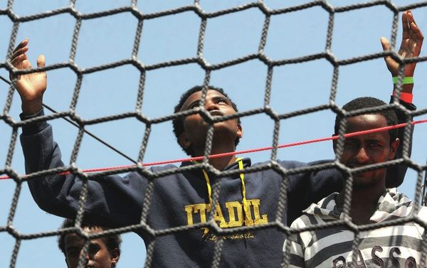 A migrant opens his arms as he waits to disembark from the German Navy ship Hessen at the Palermo harbor, Italy. - Sputnik International