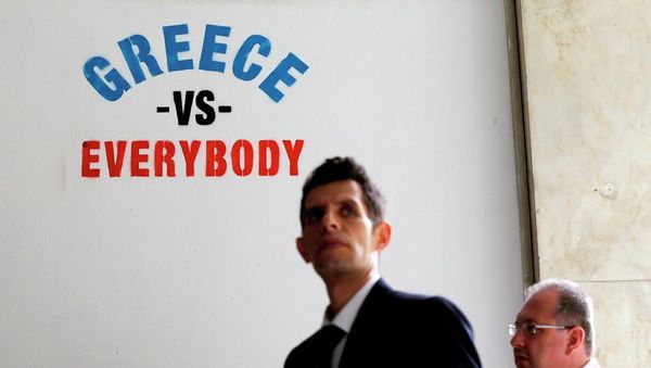 Pedestrians walk past stenciled graffiti on a wall outside of a bank in Athens. - Sputnik International