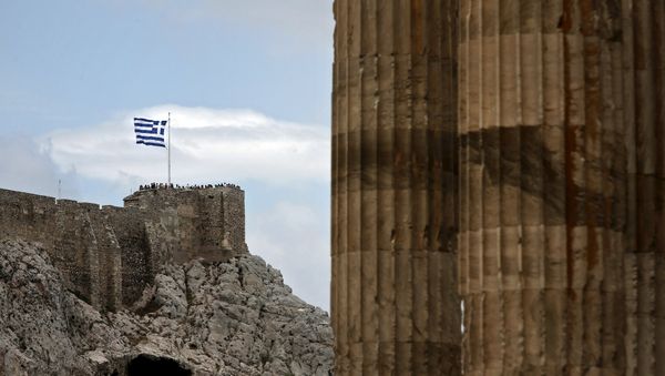 People stand next to a fluttering Greek national flag at the ancient site of the Athens' Acropolis as marble columns of the Temple of the Olympian Zeus are seen on the right June 7, 2015 People stand next to a fluttering Greek national flag at the ancient site of the Athens' Acropolis as marble columns of the Temple of the Olympian Zeus are seen on the right June 7, 2015 - Sputnik International