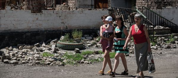 Residents walk in front of destroyed building as a result of shelling on June 8, 2015 in Novotoshkivske village, Donetsk region Residents walk in front of destroyed building as a result of shelling on June 8, 2015 in Novotoshkivske village, Donetsk region - Sputnik International