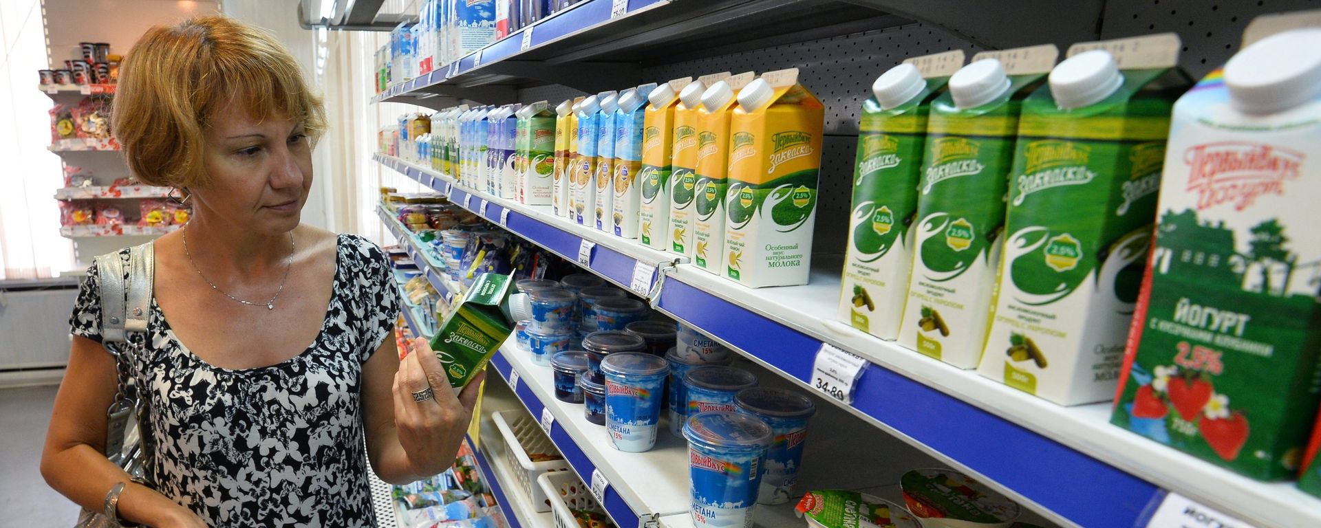 A buyer near the shelf with dairy products - Sputnik International, 1920, 22.03.2022