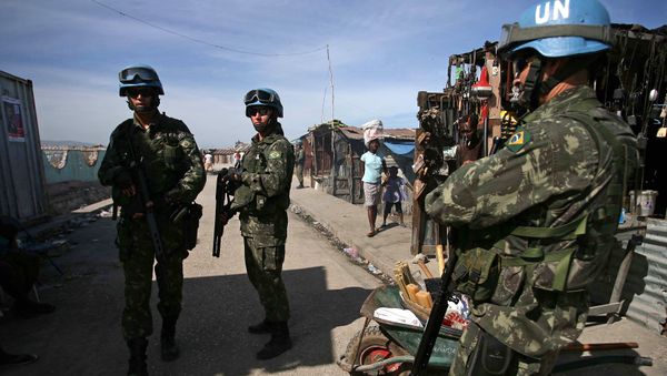 Brazilian UN peacekeepers patrol through Cite Soleil, the biggest slum on the outskirts of the Haitian capital Port-au-Prince, on November 22, 2010 - Sputnik International