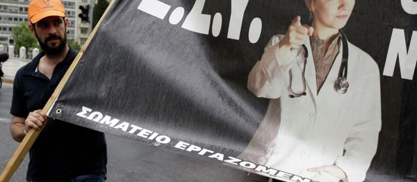 A health worker holds a banner that reads National Health System (E.S.Y.) during a strike protesting understaffing and underfunding and demanding back pay in Athens, Wednesday, May 20, 2015 - Sputnik International