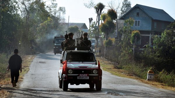 In this photograph taken on February 18, 2012, a vehicle carrying armed security personnel passes along a road on the outskirts of Imphal in the north eastern Indian state of Manipur - Sputnik International