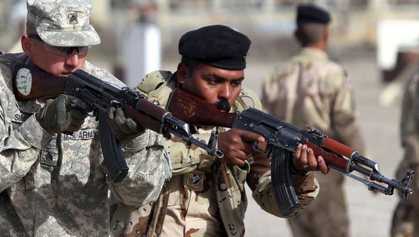 An American military trainer instructs an Iraqi soldier during an exercise on approaching and clearing buildings at the Taji base complex, which hosts Iraqi and US troops and is located north of the capital Baghdad, on January 7, 2015 - Sputnik International