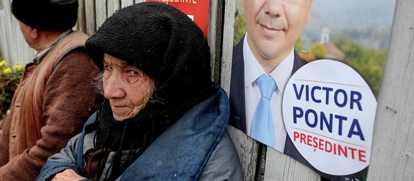 An elderly woman, back dropped by a campaign poster of Romanian Prime Minister Victor Ponta in 2011. An elderly woman, back dropped by a campaign poster of Romanian Prime Minister Victor Ponta in 2011. - Sputnik International