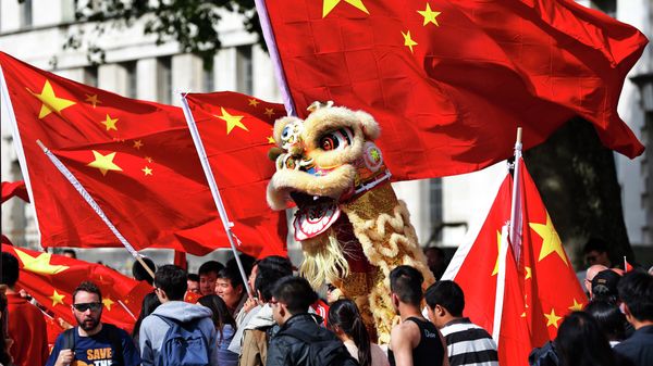 Chinese students hold a puppet depicting a dragon and  wave their national flags - Sputnik International