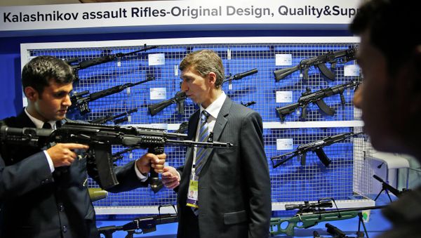 A Russian exhibitor from Kalashnikov, center, explains the working of an AK-104 at the 8th International Land and Naval Defense system exhibition, in New Delhi, India, Thursday, Feb. 6, 2014 A Russian exhibitor from Kalashnikov, center, explains the working of an AK-104 at the 8th International Land and Naval Defense system exhibition, in New Delhi, India, Thursday, Feb. 6, 2014 - Sputnik International