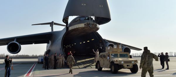 Ukrainian and US servicemen unload armoured cars from a plane at Kiev airport on March 25, 2015 during a welcoming ceremony of the first US plane delivery of non-lethal aid, including 10 Humvee vehicles Ukrainian and US servicemen unload armoured cars from a plane at Kiev airport on March 25, 2015 during a welcoming ceremony of the first US plane delivery of non-lethal aid, including 10 Humvee vehicles - Sputnik International
