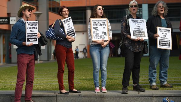Protesters hold up placards at a rally in Sydney - Sputnik International