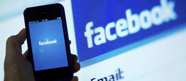 In this May 10, 2012 file photo, a view of and Apple iPhone displaying the Facebook app's splash screen in front of the login page on a computer are shown in Washington, DC - Sputnik International