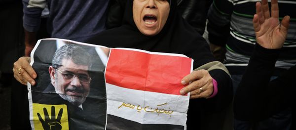A supporter of the Muslim Brotherhood movement holds a placard showing ousted president Mohamed Morsi during a demonstration on January 24, 2015 in the Cairo district of Heliopolis - Sputnik International