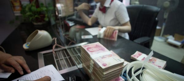 This picture taken on September 24, 2014 shows a worker of an Industrial and Commercial Bank of China Ltd (ICBC) branch counts money as she serves a customer in the China (Shanghai) Pilot Free Trade zone during a media trip - Sputnik International