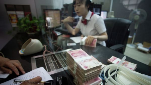 This picture taken on September 24, 2014 shows a worker of an Industrial and Commercial Bank of China Ltd (ICBC) branch counts money as she serves a customer in the China (Shanghai) Pilot Free Trade zone during a media trip - Sputnik International