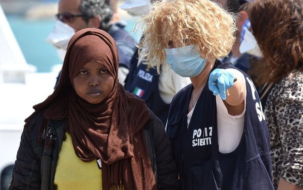 A forensic police officer gives indications to a woman as migrants arrived at Pozzallo's harbor near Ragusa, Sicily, Italy. - Sputnik International