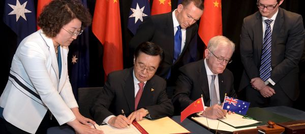 Australian Prime Minister Tony Abbott (C) watches as China's Minister of Commerce Gao Hucheng (2nd L) and Australian Minister for Trade Andrew Robb (2nd R) sign a trade agreement during an official signing ceremony in Canberra June 17, 2015 - Sputnik International
