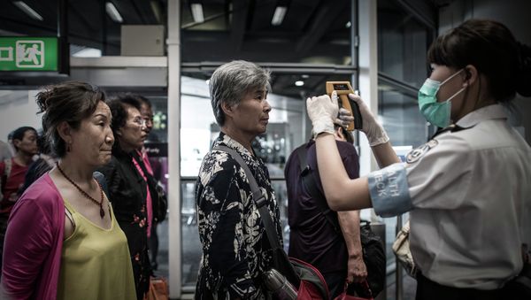 Passengers get their temperature checked as part of preventive measures against the spread of Middle East Respiratory Syndrome (MERS) at the Hong Kong international airport on June 5, 2015 Passengers get their temperature checked as part of preventive measures against the spread of Middle East Respiratory Syndrome (MERS) at the Hong Kong international airport on June 5, 2015 - Sputnik International