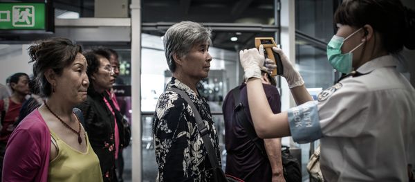Passengers get their temperature checked as part of preventive measures against the spread of Middle East Respiratory Syndrome (MERS) at the Hong Kong international airport on June 5, 2015 Passengers get their temperature checked as part of preventive measures against the spread of Middle East Respiratory Syndrome (MERS) at the Hong Kong international airport on June 5, 2015 - Sputnik International