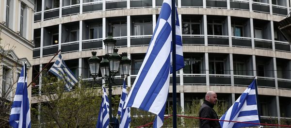 A municipal worker walks between Greek flags, which are placed on a stage for the celebrations of Orthodox Good Friday at central Metropoleos square in Athens, on Thursday, April 9, 2015 A municipal worker walks between Greek flags, which are placed on a stage for the celebrations of Orthodox Good Friday at central Metropoleos square in Athens, on Thursday, April 9, 2015 - Sputnik International