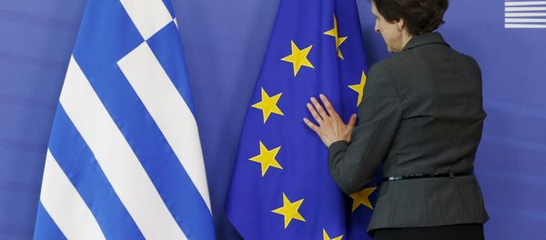 A worker adjusts flags ahead of the meeting between Greek Prime Minister Alexis Tsipras and European Commission President Jean-Claude Juncker at the EU Commission headquarters in Brussels, Belgium, June 3, 2015 - Sputnik International