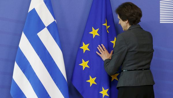 A worker adjusts flags ahead of the meeting between Greek Prime Minister Alexis Tsipras and European Commission President Jean-Claude Juncker at the EU Commission headquarters in Brussels, Belgium, June 3, 2015 - Sputnik International