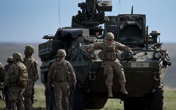 US Army serviceman jumps from armored vehicle during the NATO Wind Spring 15 military exercise at Smardan military shooting range in Romania on April 21, 2015. - Sputnik International