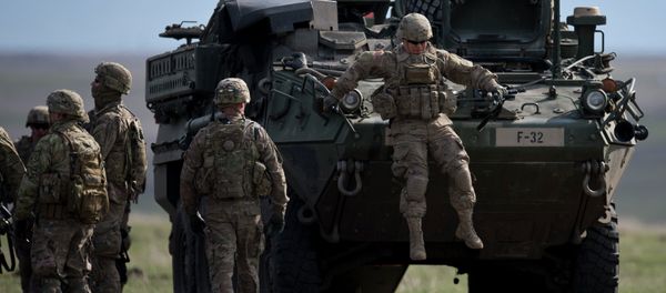 US Army serviceman jumps from armored vehicle during the NATO Wind Spring 15 military exercise at Smardan military shooting range on April 21, 2015 - Sputnik International