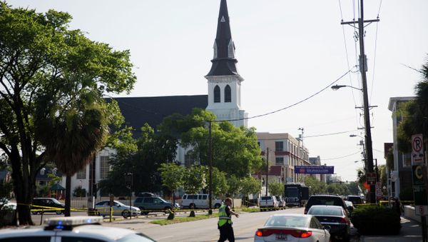 The steeple of Emanuel AME Church rises above the street as a police officer tells a car to move as the area is closed off following Wednesday's shooting, Thursday, June 18, 2015 in Charleston, S.C. - Sputnik International