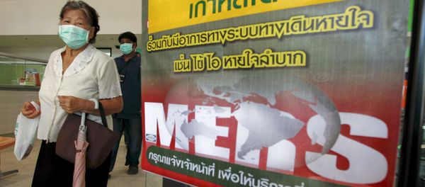 A woman wearing a mask walks past an information banner on Middle East Respiratory Syndrome (MERS) at the entrance of Bamrasnaradura Infectious Diseases Institute at a hospital in Nonthaburi province, on the outskirts of Bangkok, Thailand, June 19, 2015 - Sputnik International