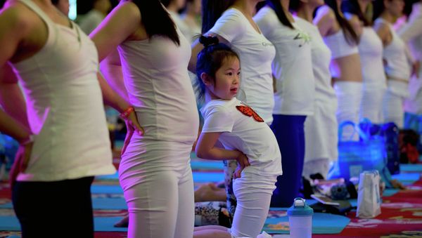 A child performs yoga at a hotel banquet hall to mark the International Yoga Day, in Changping District, on the outskirts of Beijing, China, Sunday, June 21, 2015 A child performs yoga at a hotel banquet hall to mark the International Yoga Day, in Changping District, on the outskirts of Beijing, China, Sunday, June 21, 2015 - Sputnik International