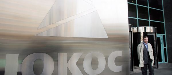 A man passes by a Yukos logo at the headquarters of the oil company in Moscow after the latest auction for the sale of package of assets the stricken giant, 04 April 2007 - Sputnik International