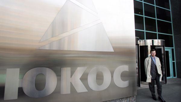 A man passes by a Yukos logo at the headquarters of the oil company in Moscow after the latest auction for the sale of package of assets the stricken giant, 04 April 2007 - Sputnik International