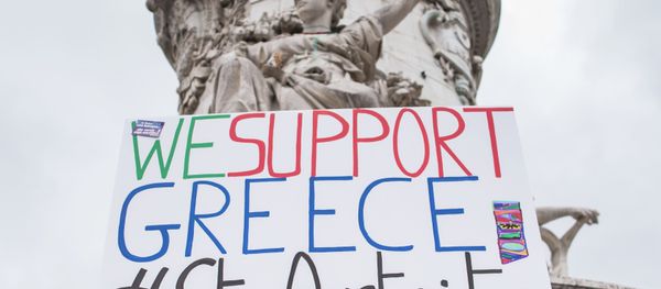 A man holds up a sign reading We support Greece #StopAusterity at the Republique Square during a demonstration against austerity in support of the Greek population in Paris, France, Saturday, June 20, 2015. - Sputnik International