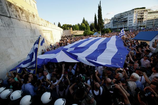 Pro-Euro demonstrators hold up a giant Greek flag outside the Greek Parliament during a rally in Athens, Monday, June 22, 2015.  - Sputnik International