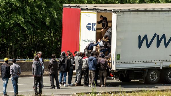 Migrants climb in the back of a lorry on the A16 highway leading to the Eurotunnel on June 23, 2015 in Calais, northern France - Sputnik International