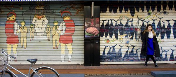 A woman stands in front of a closed shop in the outer part of the Tsukiji fish market, the Jogai Shijo, in Tokyo - Sputnik International