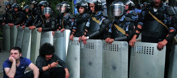 Demonstrators sit on a street in front of a line of riot police during a protest against an increase of electricity prices in the Armenian capital Yerevan on June 24, 2015 Demonstrators sit on a street in front of a line of riot police during a protest against an increase of electricity prices in the Armenian capital Yerevan on June 24, 2015 - Sputnik International