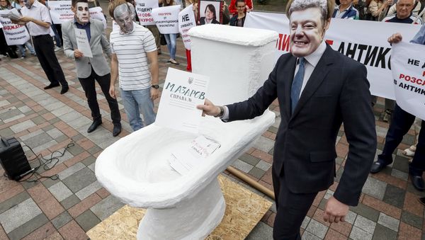 An activist wearing a mask depicting Ukrainian President Petro Poroshenko (R) places mock criminal files in a fake toilet during a performance to protest against what the activists said was corruption in the government, in front of the parliament building in Kiev, Ukraine, June 17, 2015 An activist wearing a mask depicting Ukrainian President Petro Poroshenko (R) places mock criminal files in a fake toilet during a performance to protest against what the activists said was corruption in the government, in front of the parliament building in Kiev, Ukraine, June 17, 2015 - Sputnik International