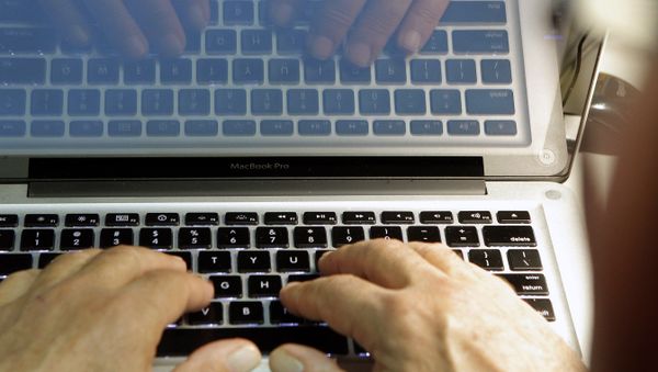 Hands type at a keyboard. - Sputnik International