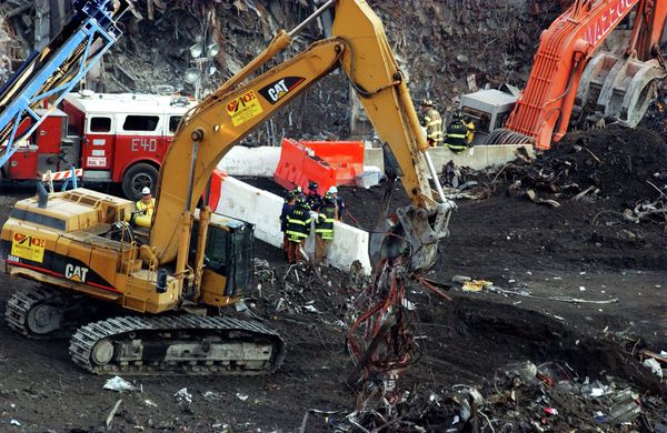 New York City firefighters and others gather around a barricade as excavators remove debris, Wednesday, Nov. 28, 2001, as the recovery and cleanup mission continued at ground zero of the World Trade Center in New York. - Sputnik International