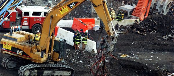 New York City firefighters and others gather around a barricade as excavators remove debris, Wednesday, Nov. 28, 2001, as the recovery and cleanup mission continued at ground zero of the World Trade Center in New York. - Sputnik International