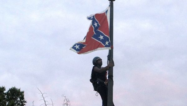 Bree Newsome of Charlotte, N.C., climbs a flagpole to remove the Confederate battle flag at a Confederate monument in front of the Statehouse in Columbia, S.C., on Saturday, June, 27, 2015. - Sputnik International
