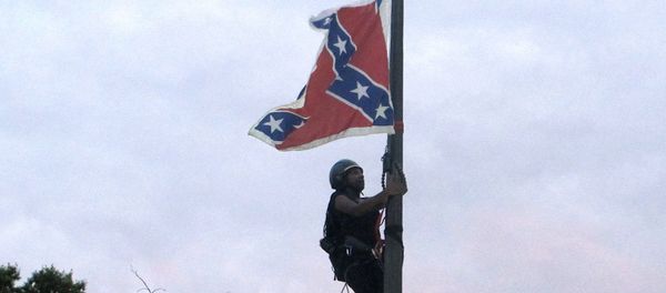 Bree Newsome of Charlotte, N.C., climbs a flagpole to remove the Confederate battle flag at a Confederate monument in front of the Statehouse in Columbia, S.C., on Saturday, June, 27, 2015. - Sputnik International