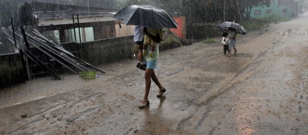 A woman carries her children in the rain as she walks by homes destroyed by flooding in Alajuela, Costa Rica A woman carries her children in the rain as she walks by homes destroyed by flooding in Alajuela, Costa Rica - Sputnik International